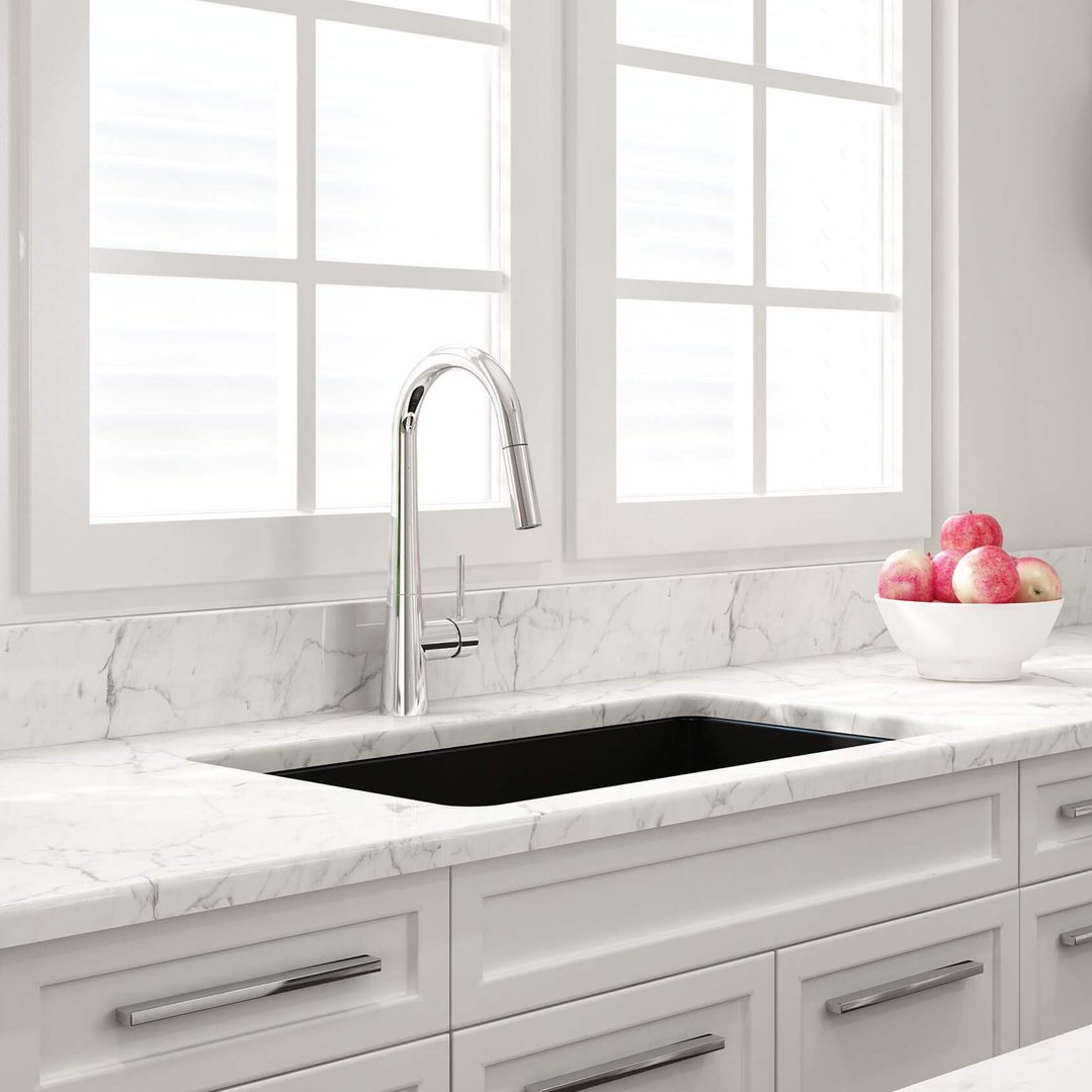 Matte black sink and chrome faucet in a kitchen with white marble countertops