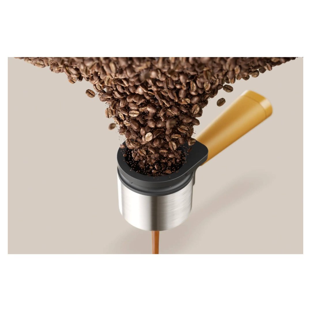 Coffee beans falling into a portafilter, with coffee brewing from the bottom