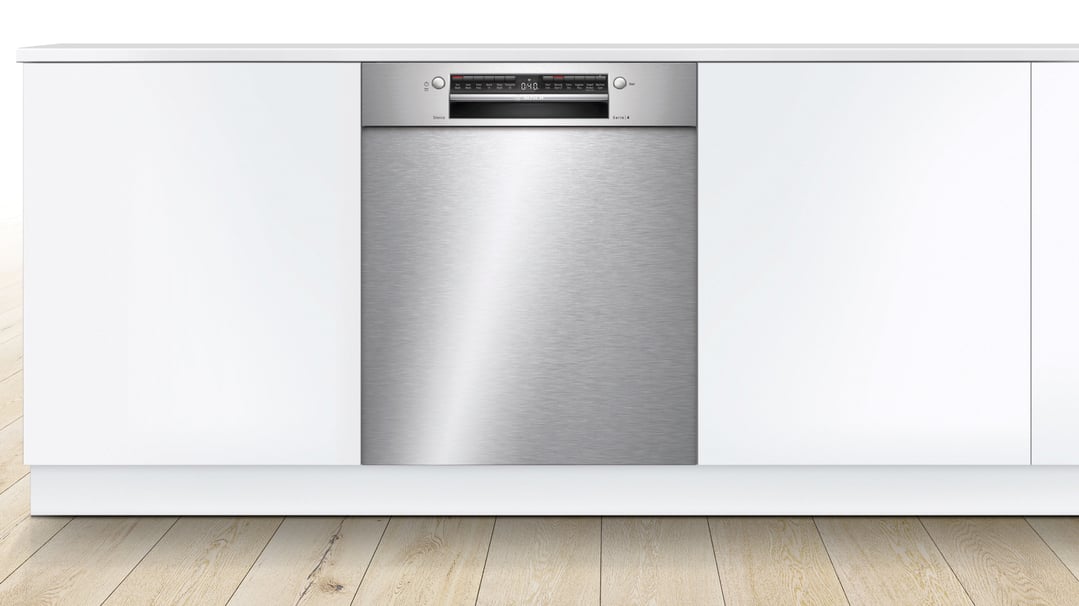 Built-under stainless steel dishwasher with control panel in a white kitchen setting