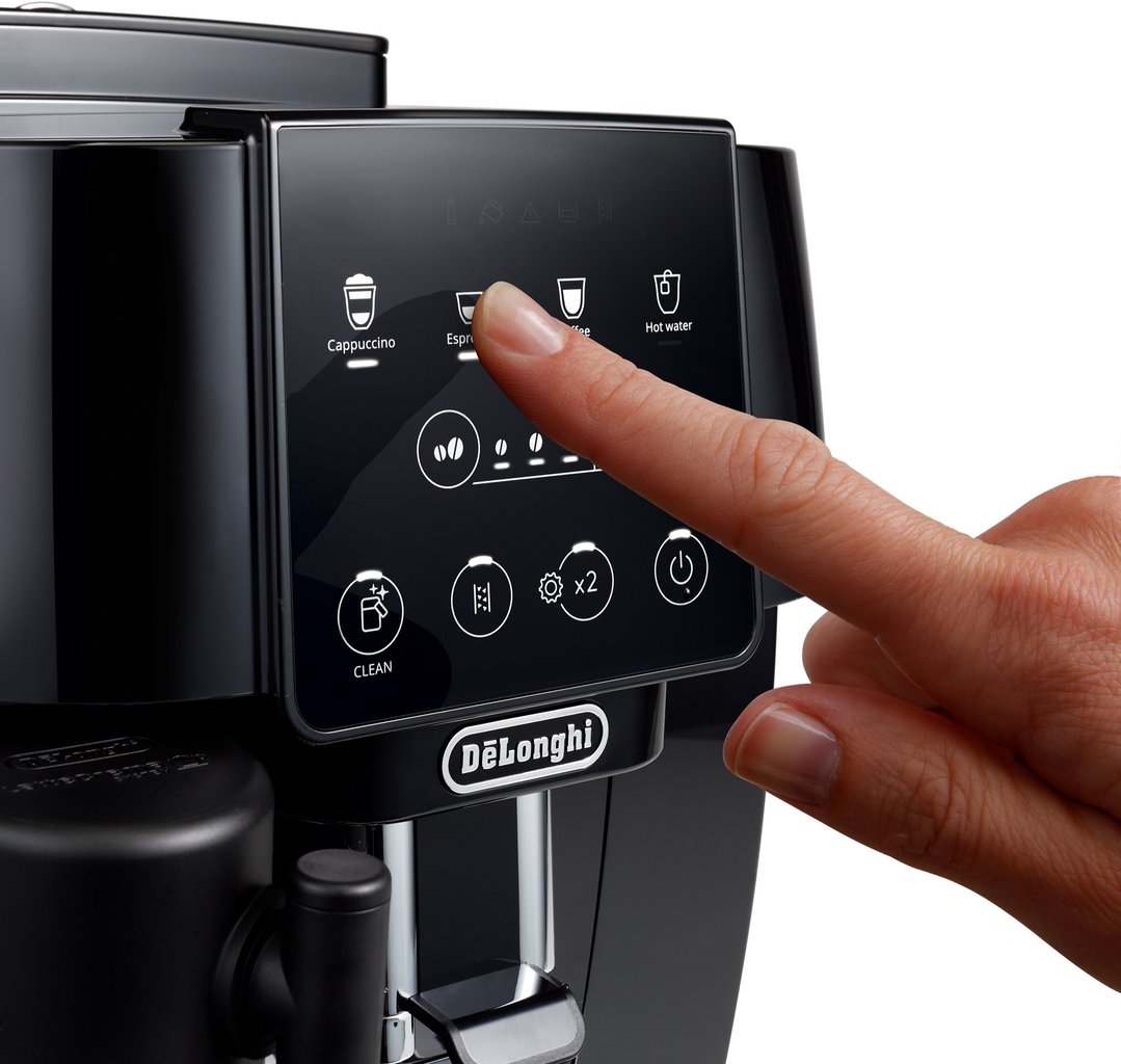 Hand pressing the espresso button on a black De'Longhi coffee machine