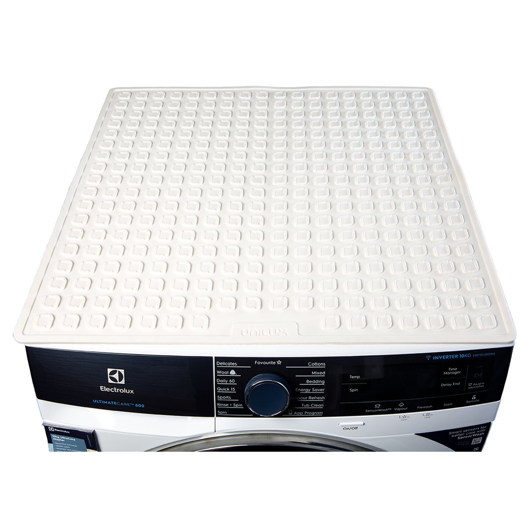 White appliance mat on top of a black and white washing machine