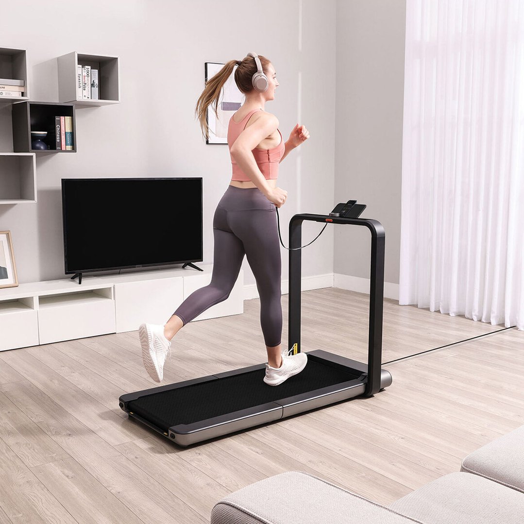 Woman running on a foldable treadmill in a modern living room