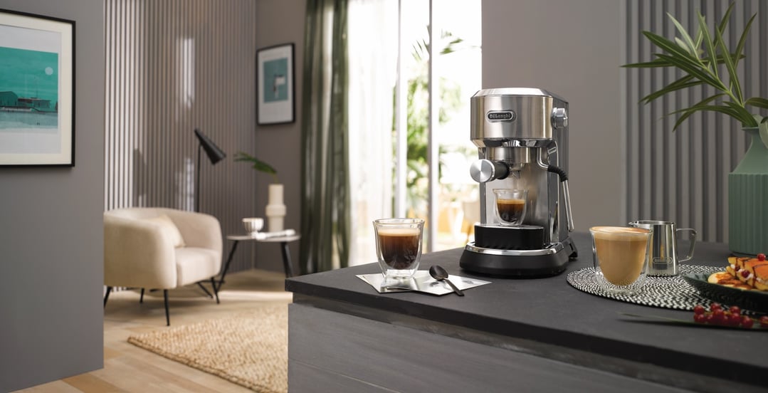 Manual coffee machine on a kitchen counter with coffee cups and breakfast