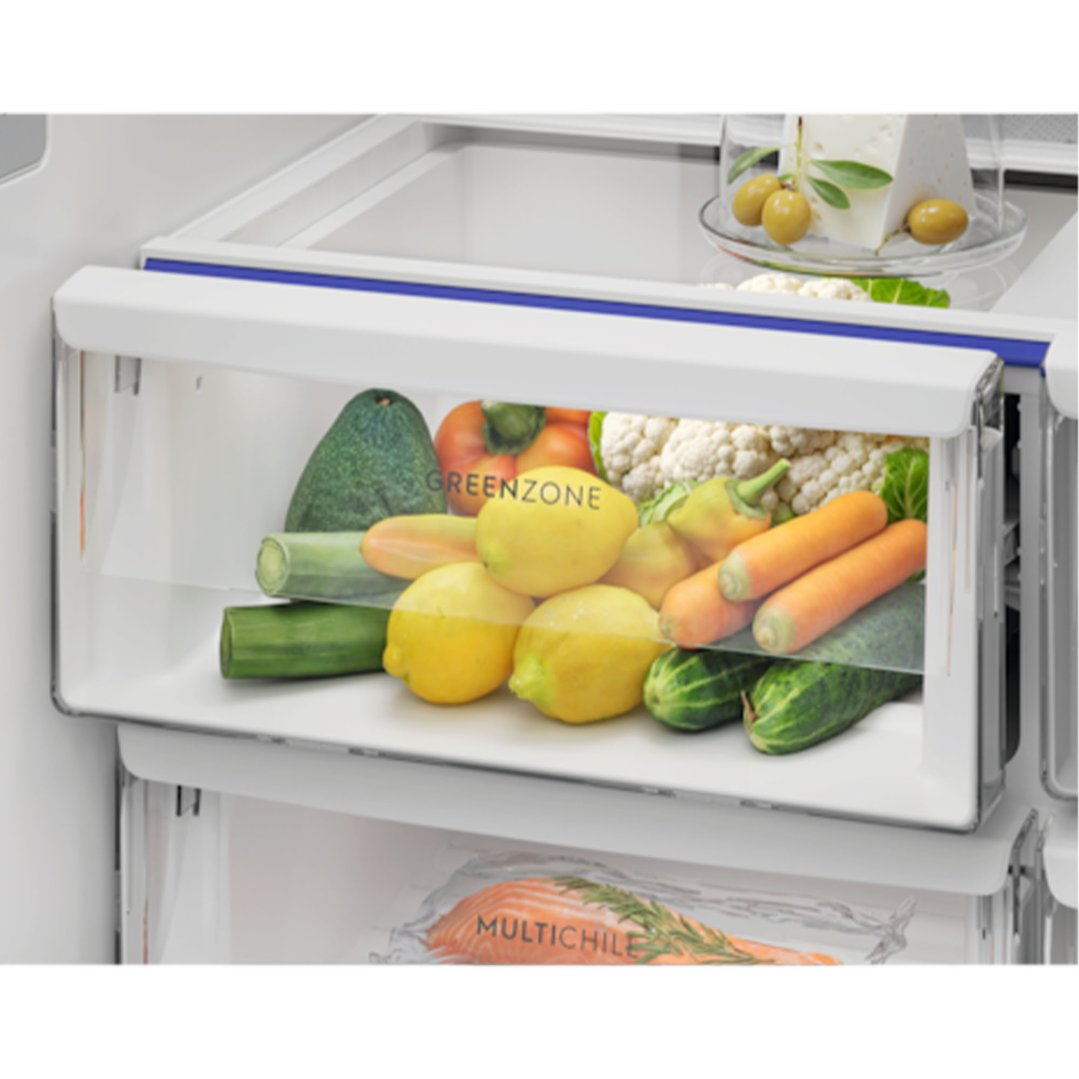 Open fridge drawer with fresh vegetables and fruit, and cheese on a shelf