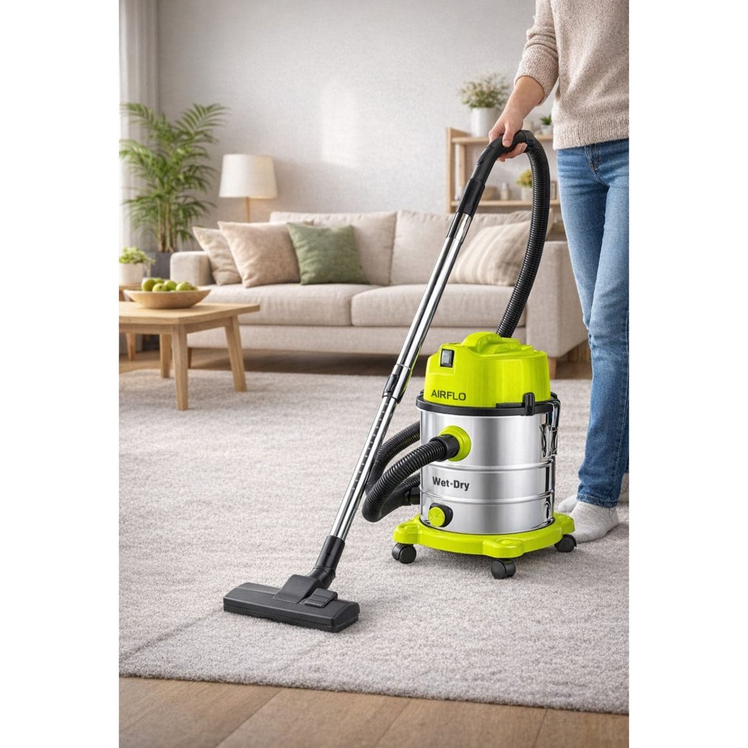 Woman vacuuming a light-colored rug in a living room with a wet and dry vacuum cleaner