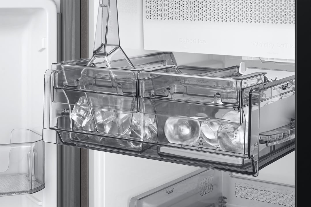 Close-up of the refrigerator's ice maker with cubed and whisky ball ice