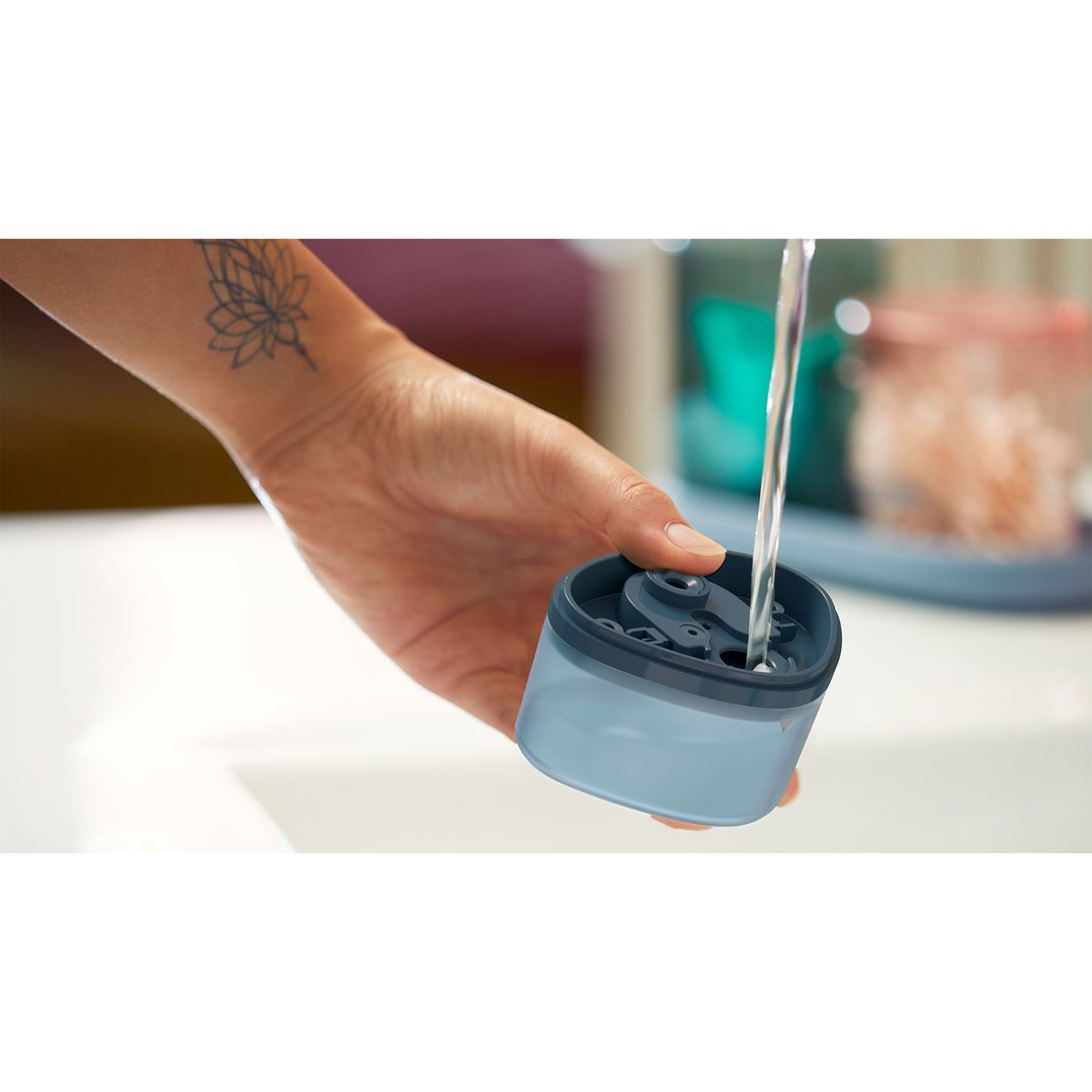 Hand filling the Garment Steamer's water tank under a running tap
