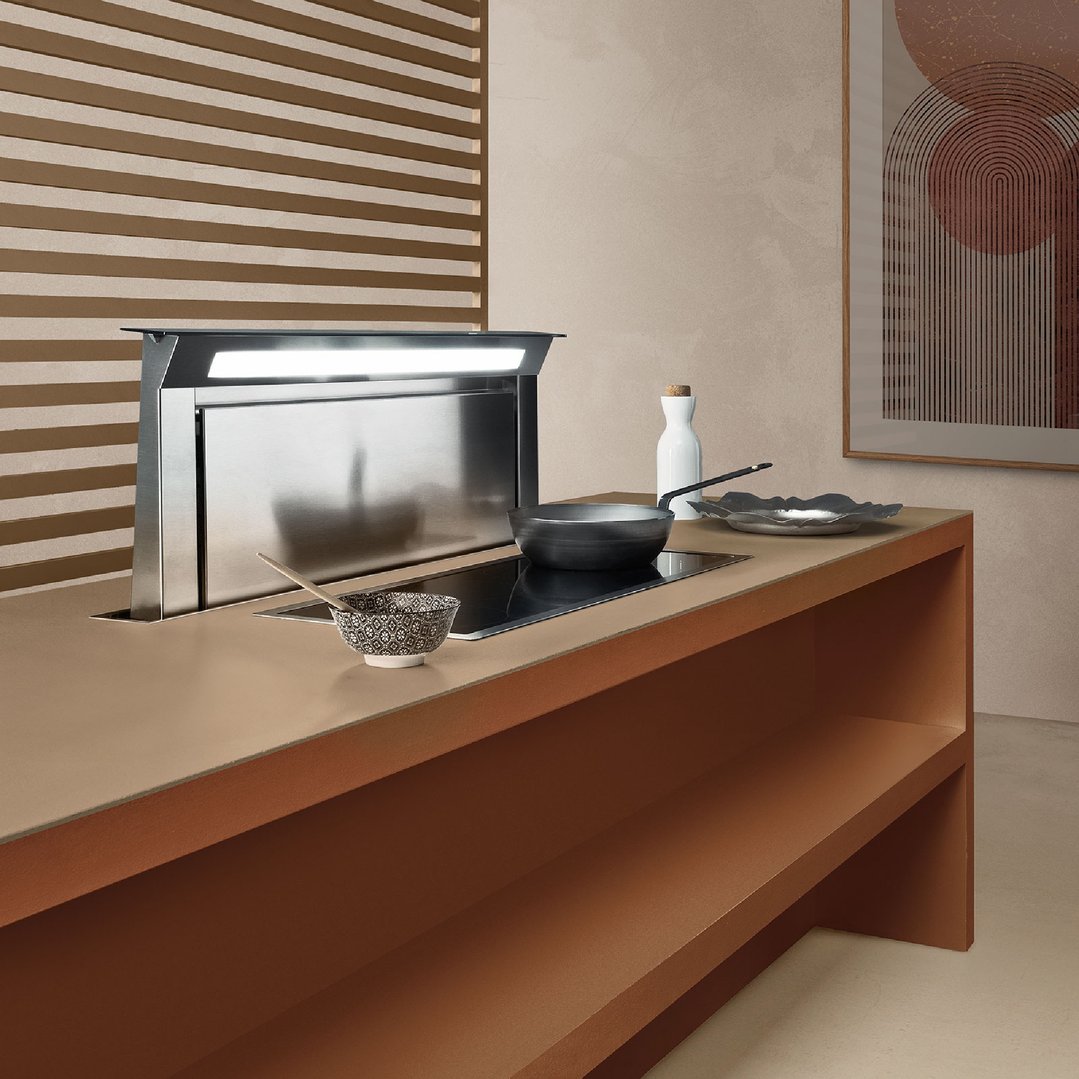 Downdraft rangehood with an induction cooktop and cooking utensils in a modern kitchen