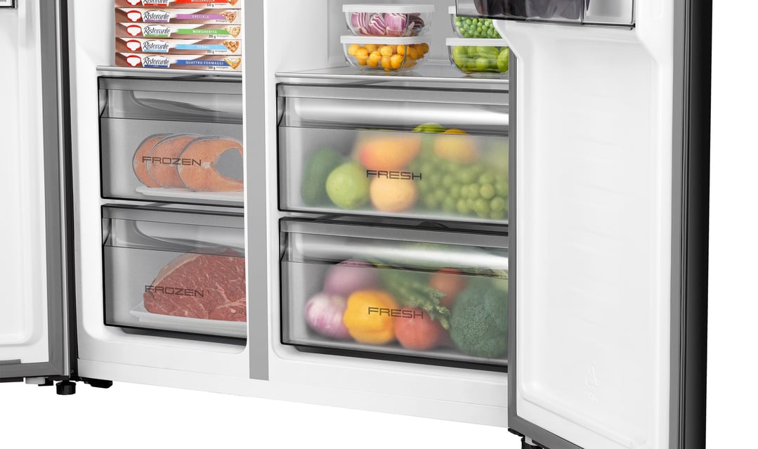 Open side-by-side fridge showing frozen salmon, meat, and fresh produce