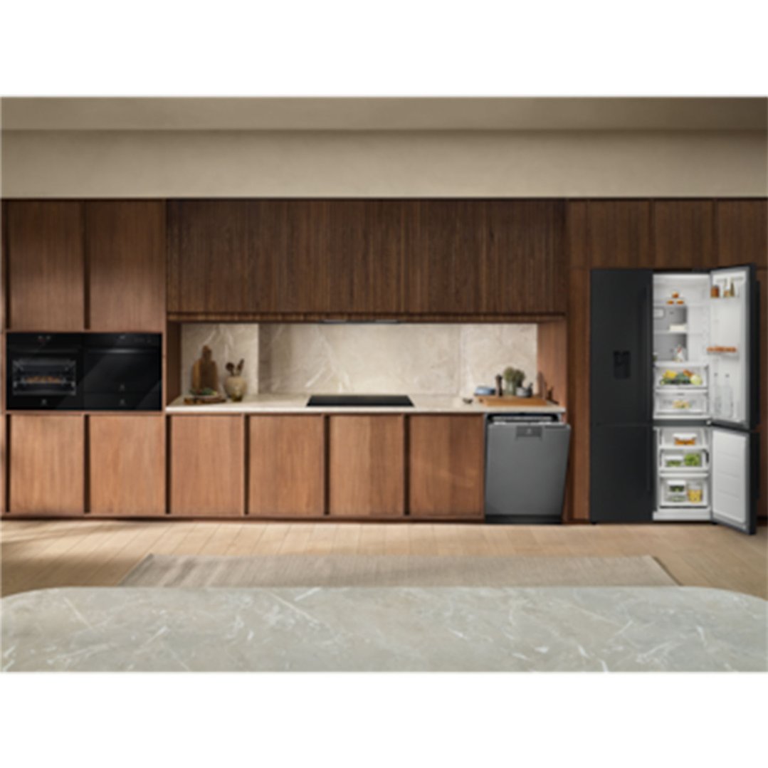Black built-in ovens, dishwasher, and refrigerator in a modern kitchen