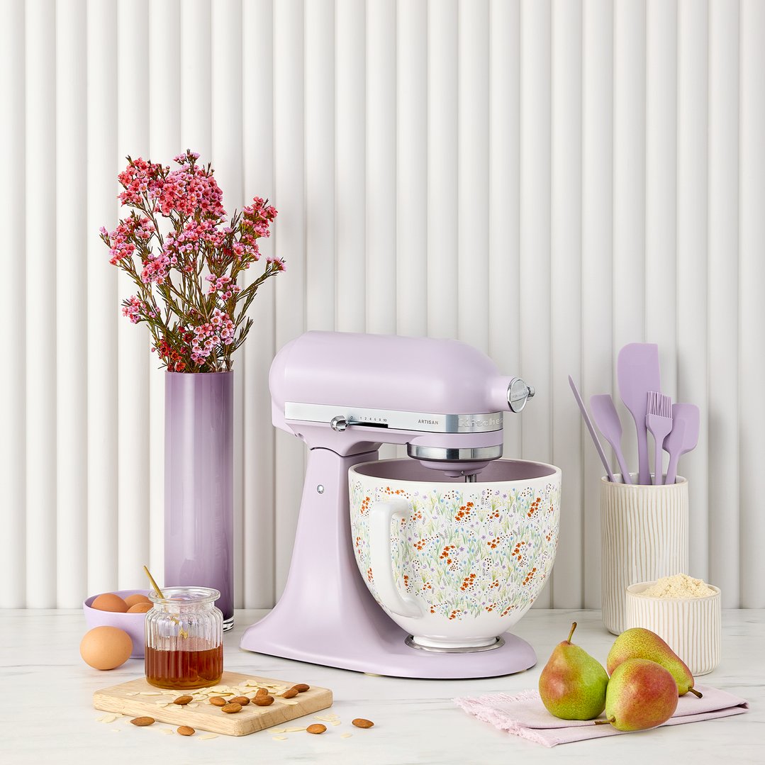 Purple KitchenAid stand mixer with floral bowl on a kitchen counter with ingredients