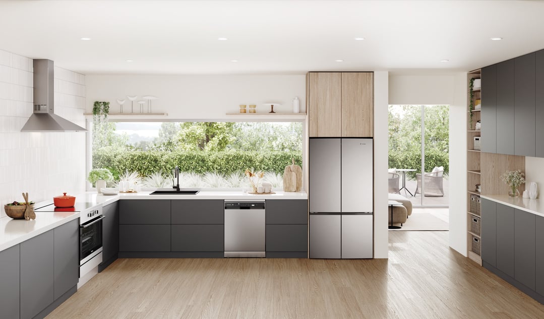 A stainless steel quad door refrigerator in a modern kitchen with wooden cabinets