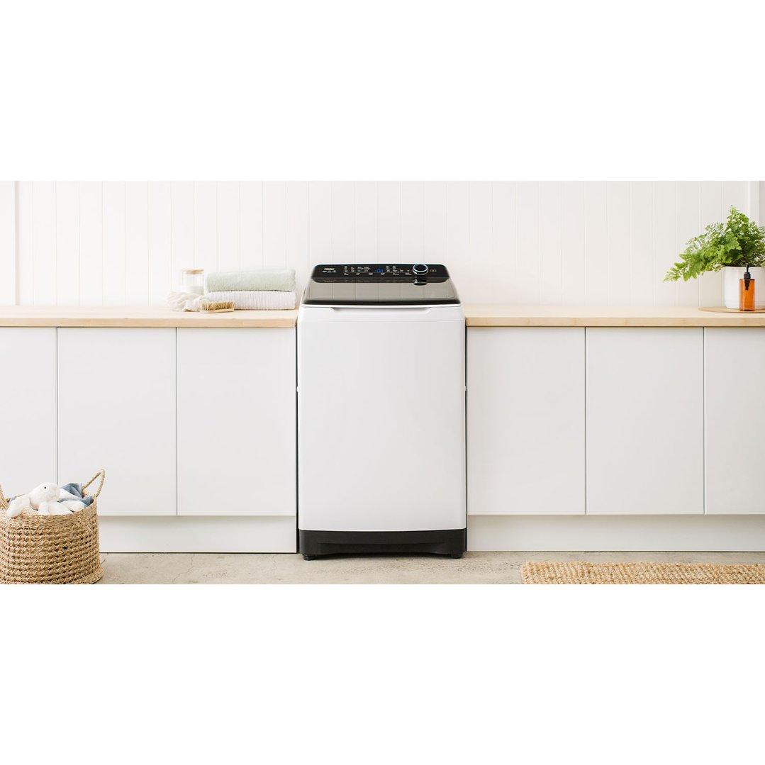 White top loader washing machine in a modern laundry room setting