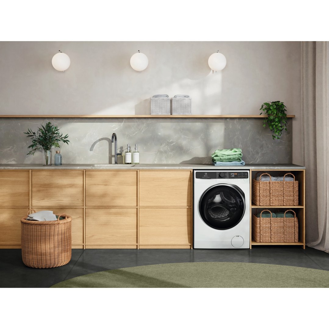 Electrolux washer dryer combo in a modern laundry room with wooden cabinets