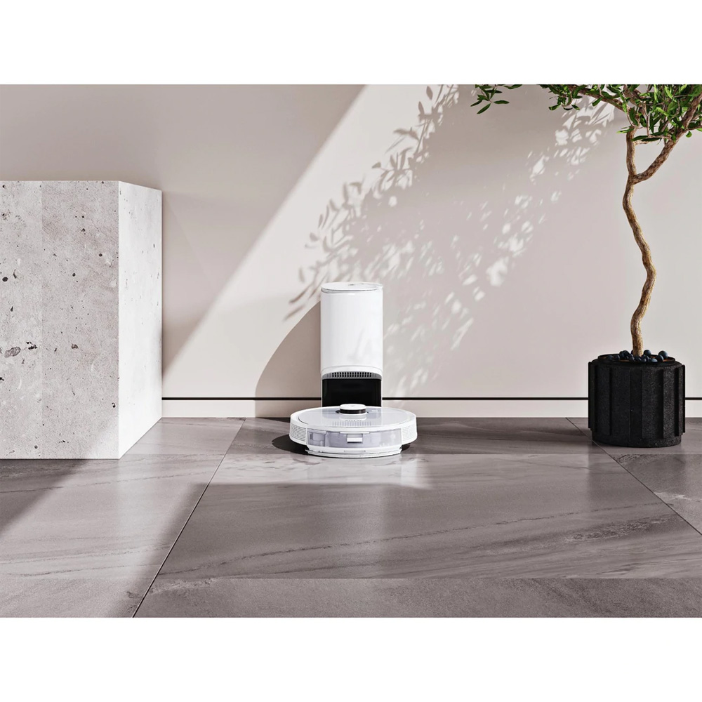 Ecovacs Deebot T9+ robotic vacuum charging in a modern room with plant