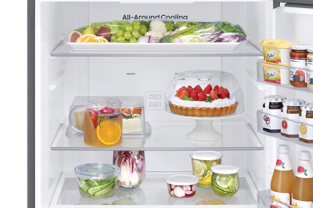 Open refrigerator interior filled with various fresh foods and beverages on shelves