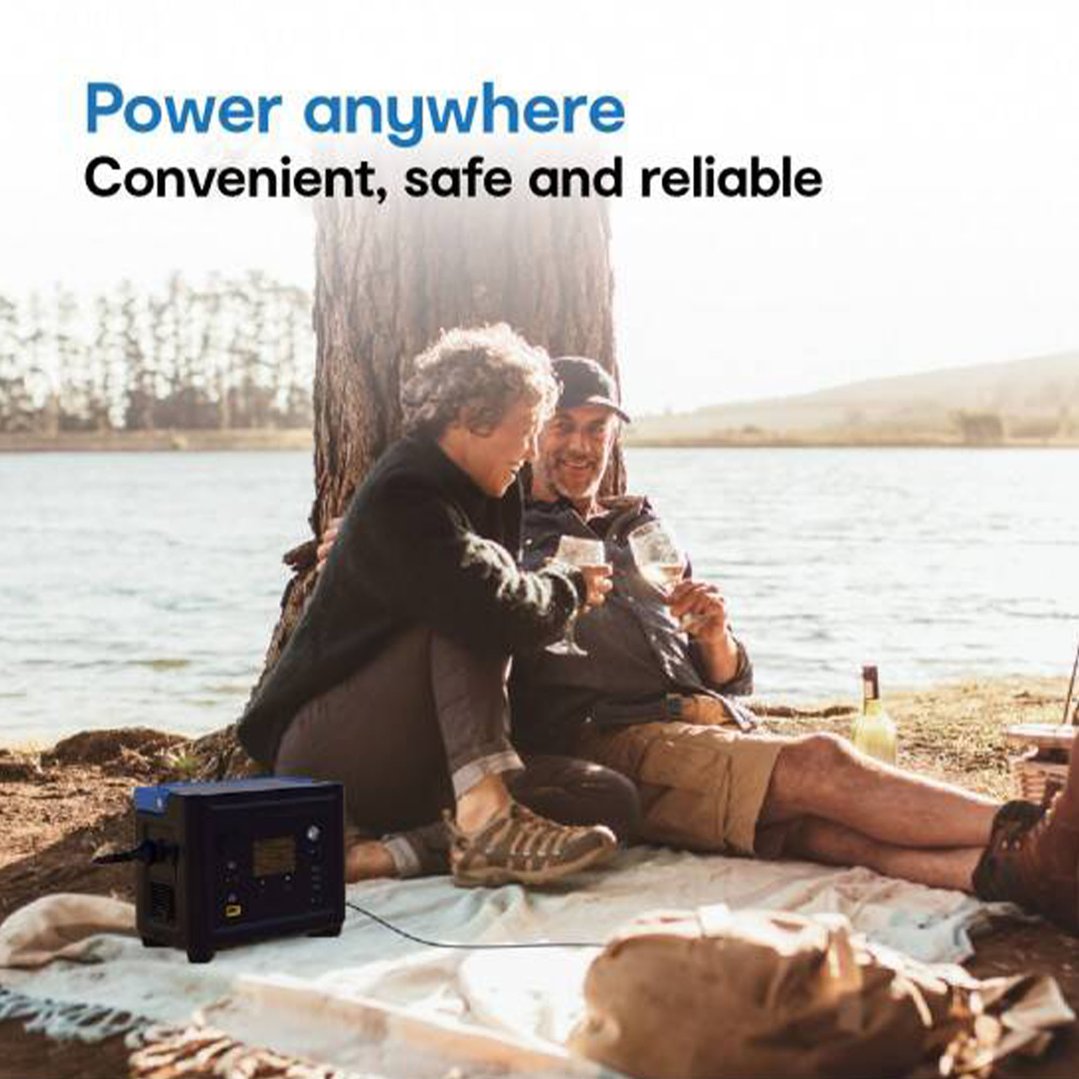 Two people enjoying a picnic by the water with a portable power station