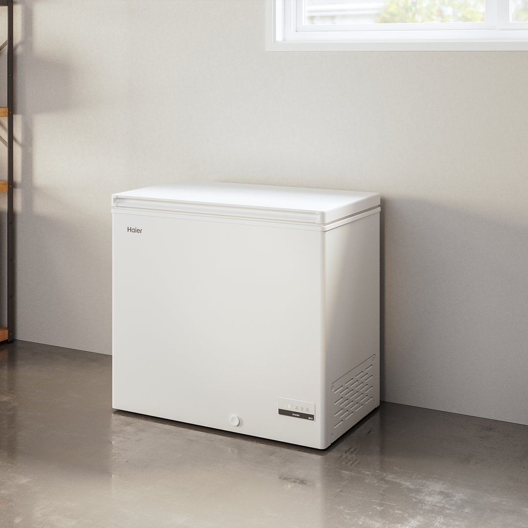 White Haier chest freezer in a room with a window and concrete floor