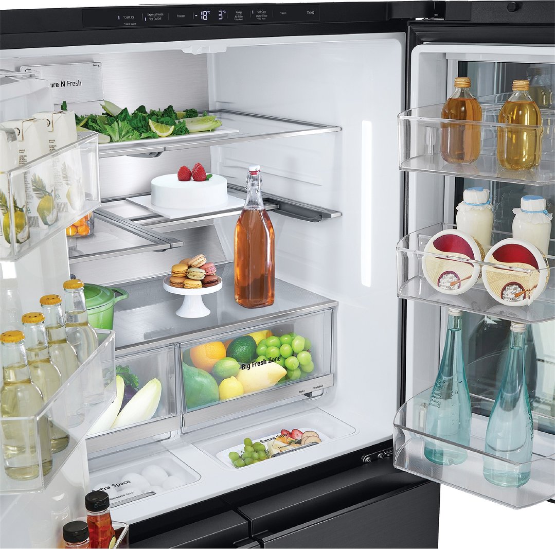Open fridge interior filled with food, drinks, and desserts