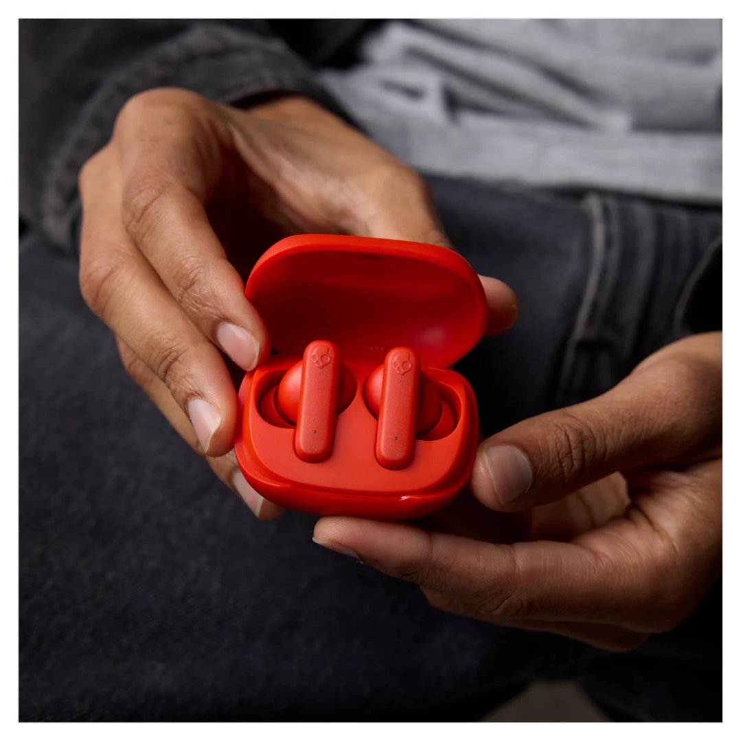 Hands holding an open red case with two red Smokin Buds TWS in-ear headphones