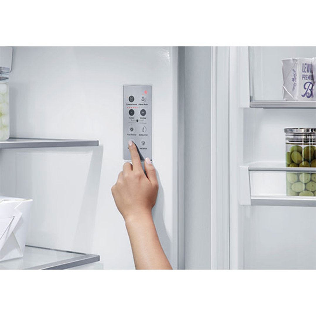 Hand adjusting the internal control panel of a French door refrigerator freezer
