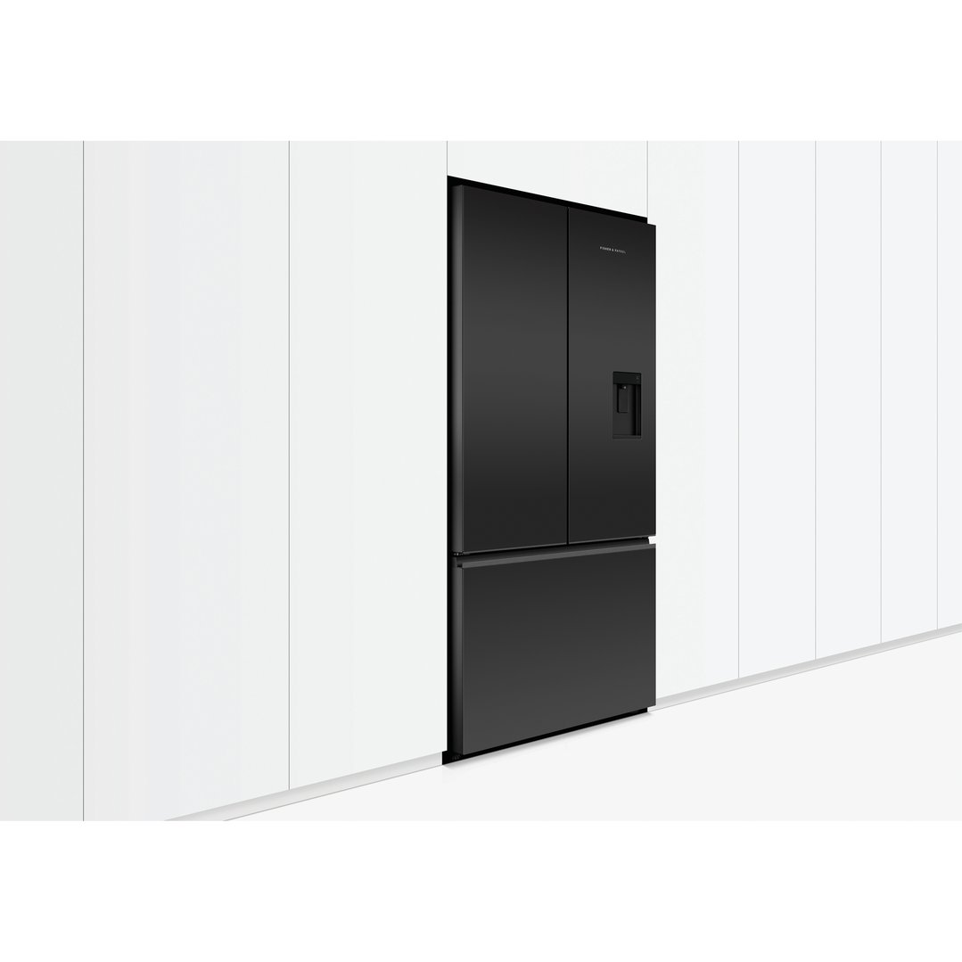 Black French door refrigerator freezer with ice and water dispenser built into a white wall