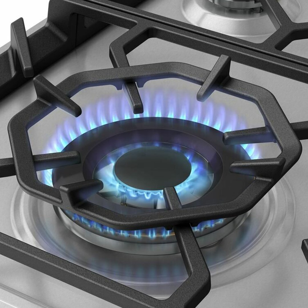 Close up of a gas cooktop burner with blue flames ignited