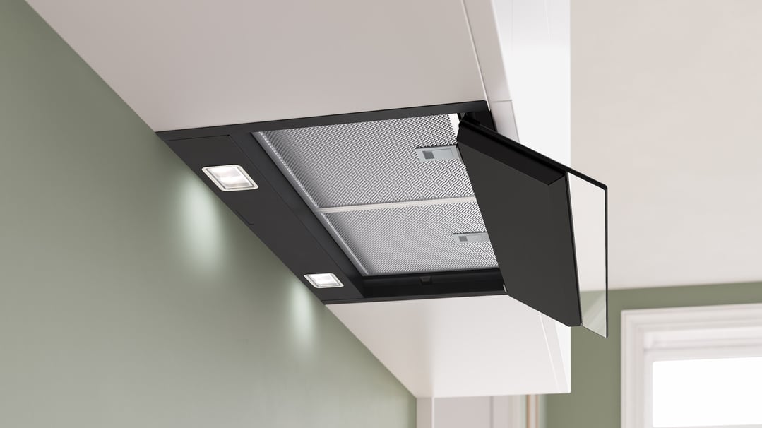 Black integrated rangehood with lights on in a modern kitchen setting