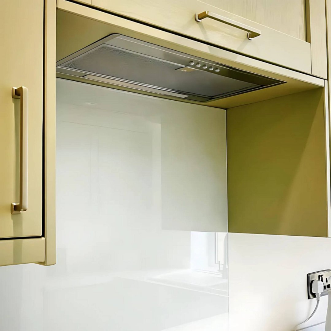 Undermount rangehood installed in a kitchen cabinet with a white splashback