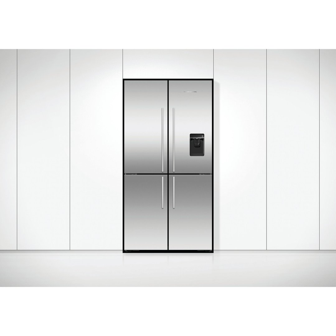 Stainless steel quad door refrigerator freezer with ice and water dispenser in a kitchen