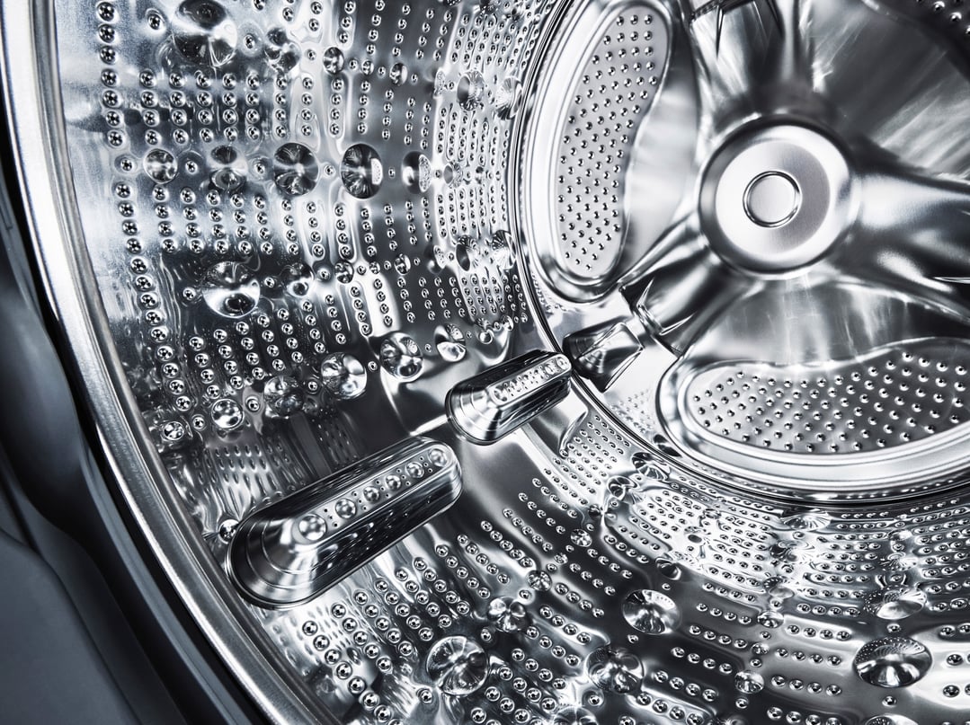 Close-up of the shiny metallic interior drum of a washing machine