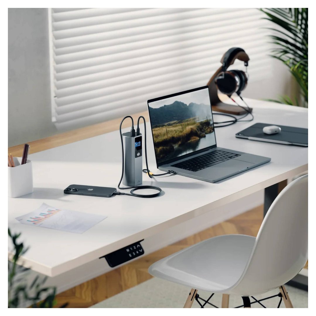 ALOGIC power bank charging a laptop and phone on a white desk