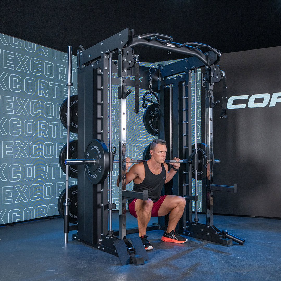 Man performing squats with a barbell on a power rack in a gym setting