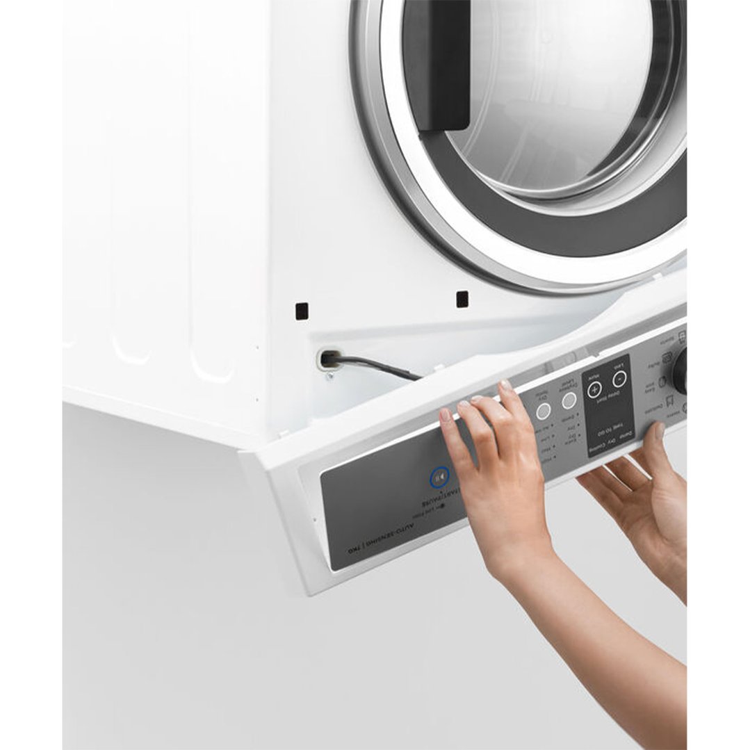 Hands adjusting the control panel of a white vented dryer