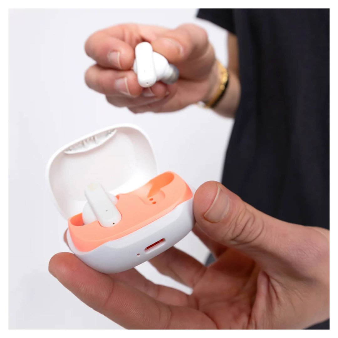 Person holding a white and orange earbud charging case with one earbud inside