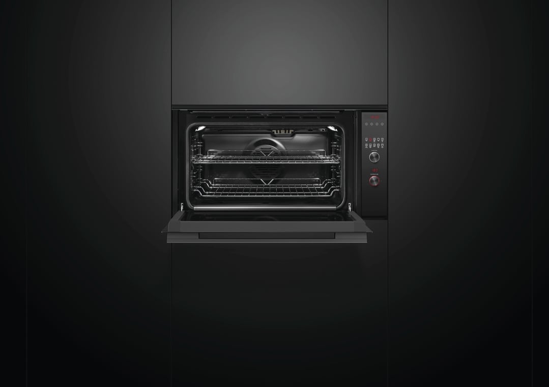Black built-in oven with the door open, showing the interior racks