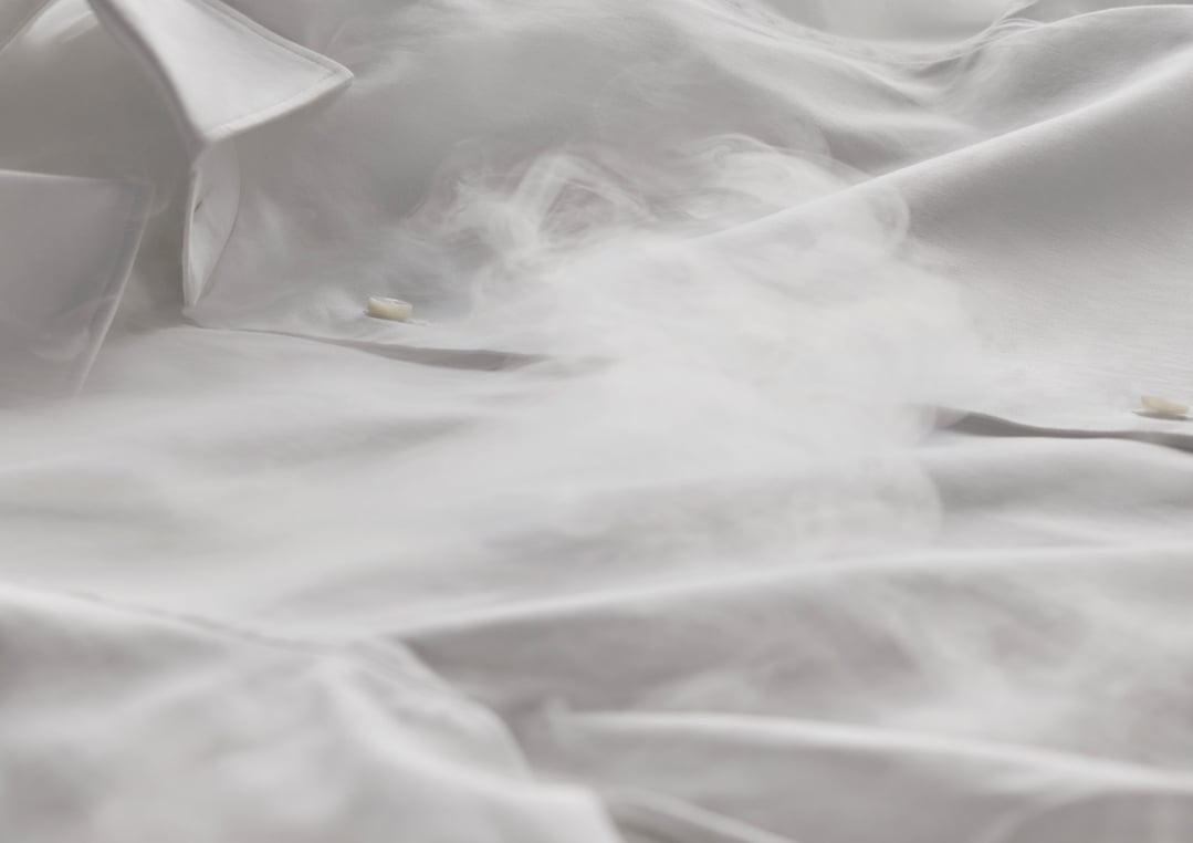 Close up of white fabric with steam, possibly from a washing machine