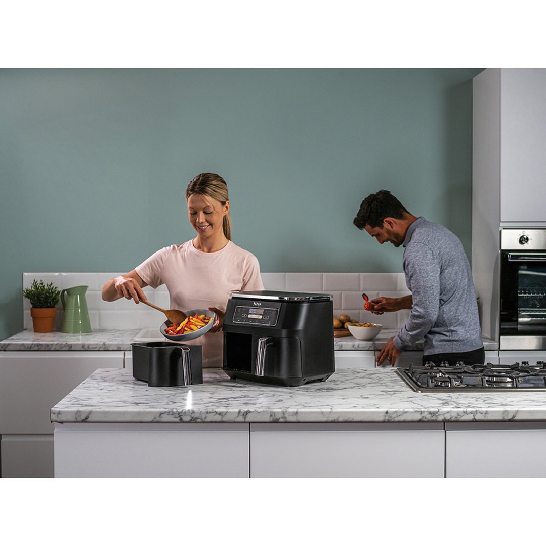 Man and woman preparing food with a Ninja Foodi Dual Zone Air Fryer