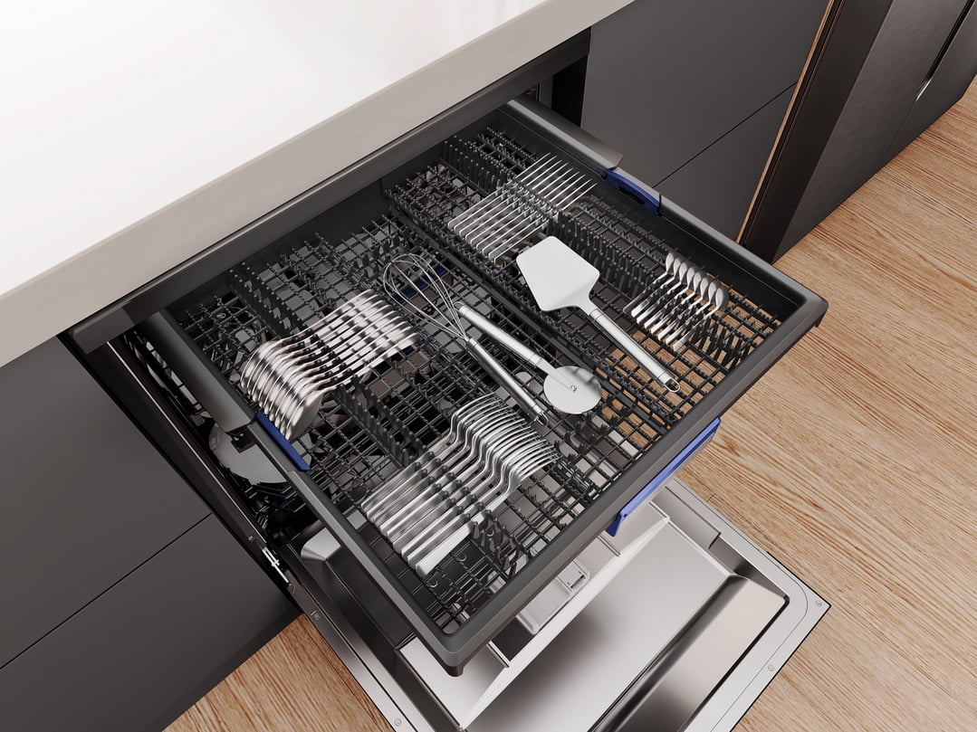 Top-down view of a dishwasher with the top rack full of cutlery