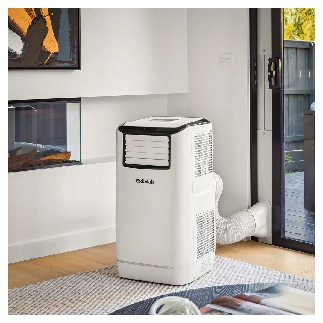 White portable air conditioner in a living room next to a fireplace