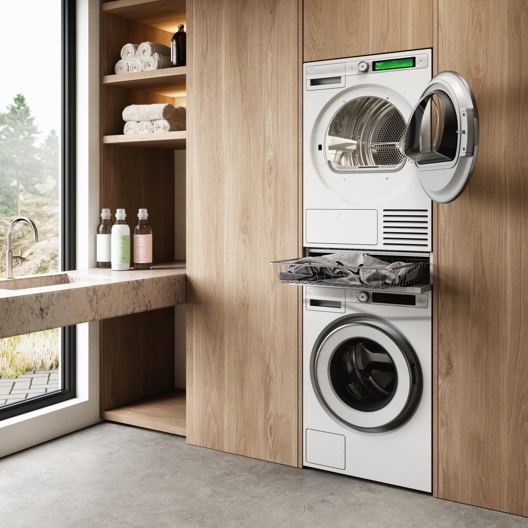 Laundry room with stacked washer and dryer, pull-out basket, and sink