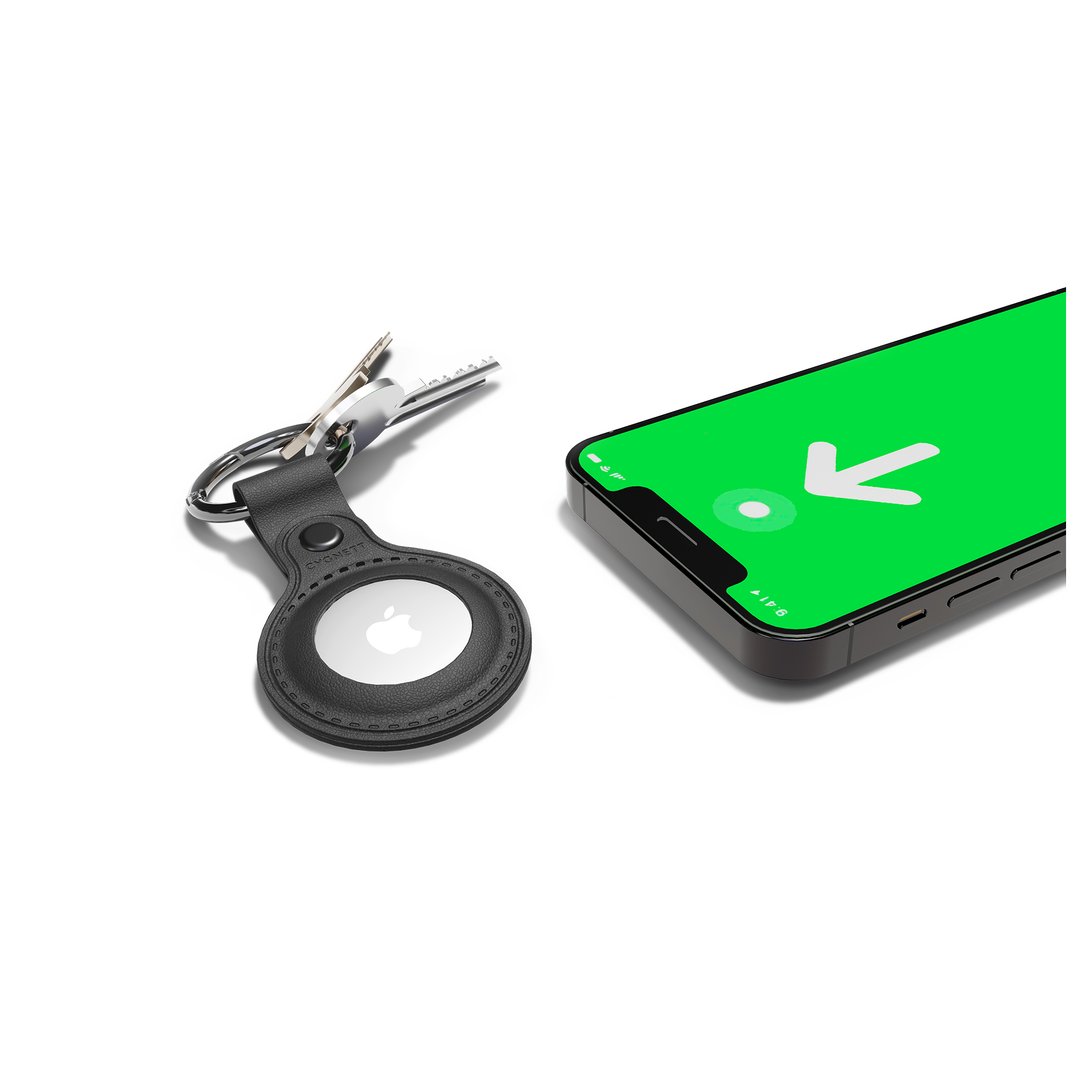 Black AirTag case with keys next to a smartphone displaying a tracking app