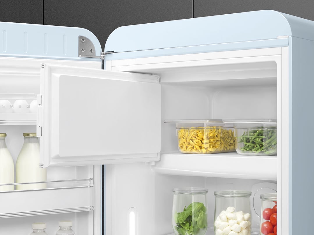 Open pastel blue SMEG refrigerator with food items on shelves and in door