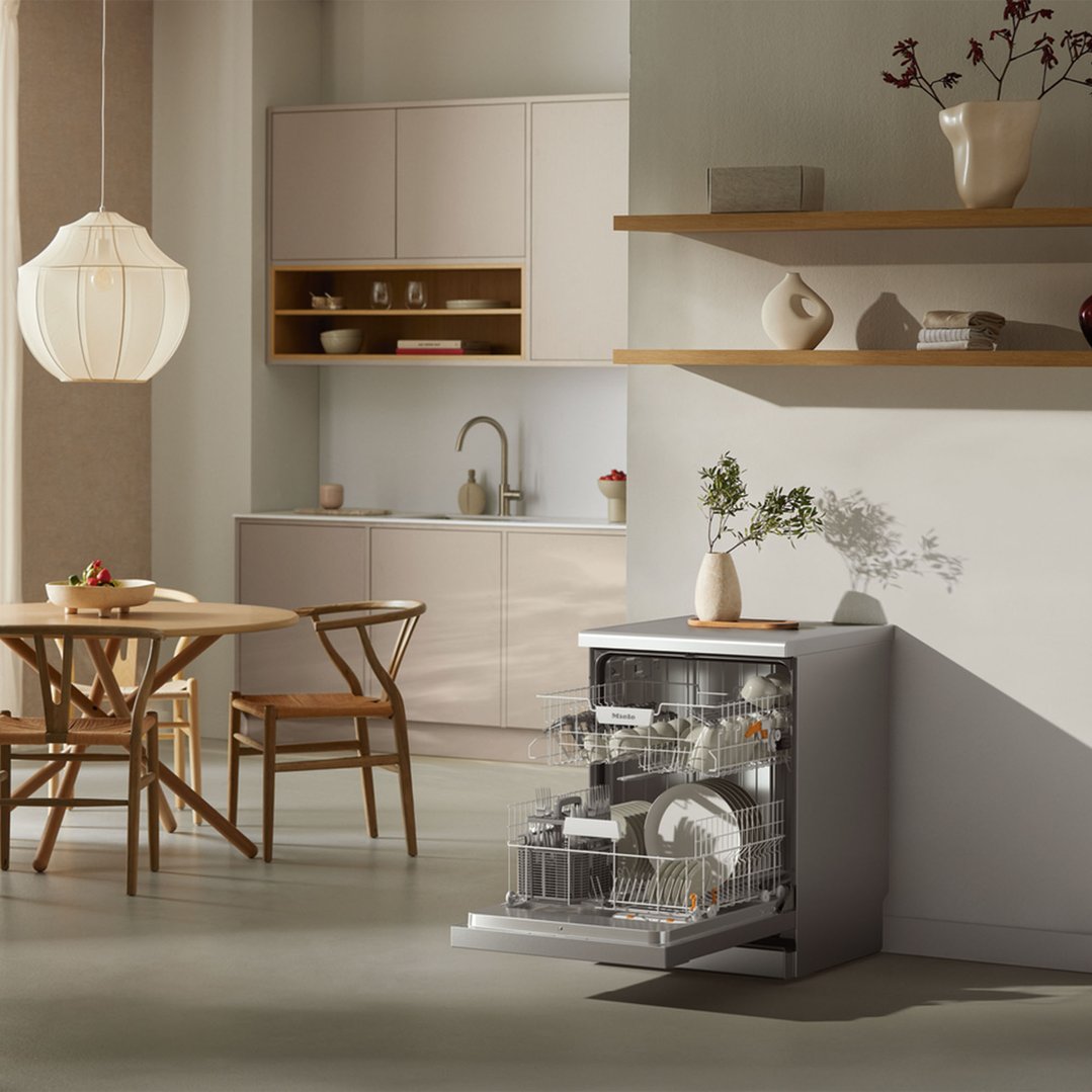 Freestanding dishwasher with open door in a modern kitchen and dining area