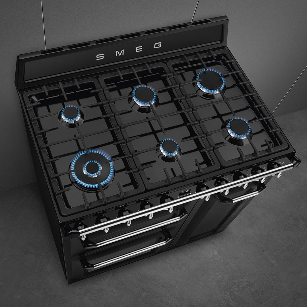 Black freestanding dual fuel oven/stove with six gas burners on a dark surface