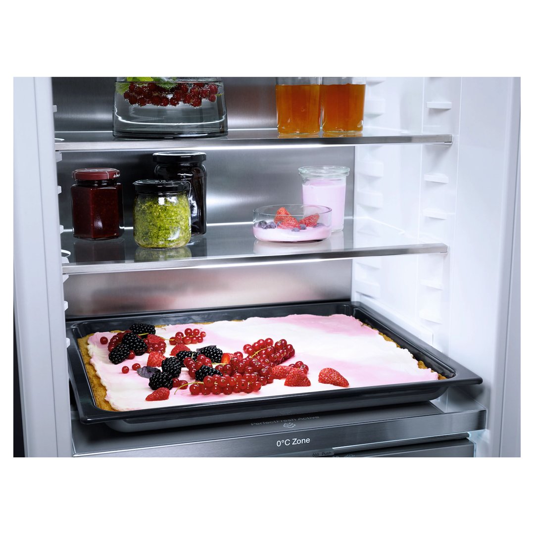 Integrated fridge interior with food items and a berry tart on a tray