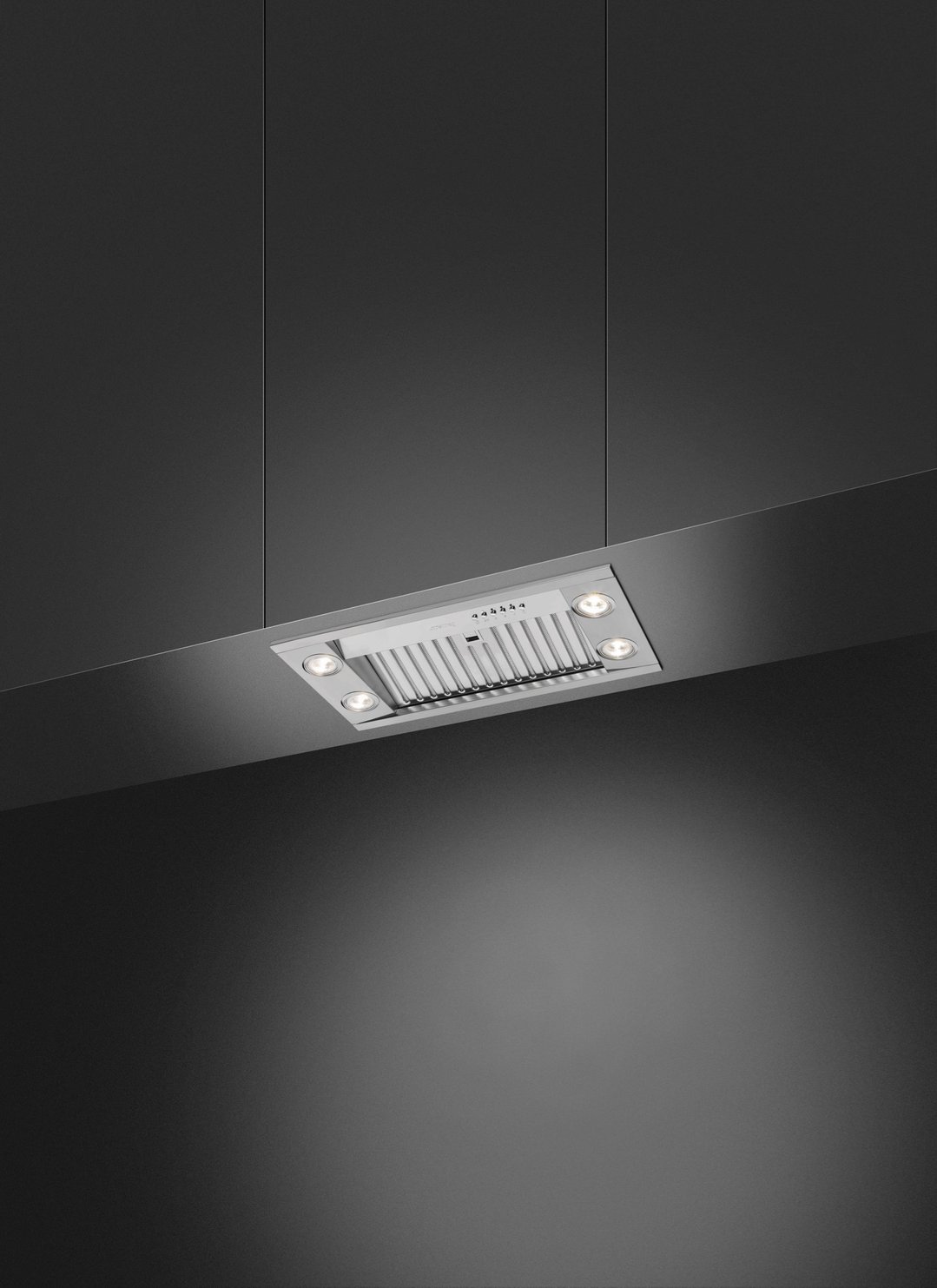 Undermount rangehood with lights on, installed in a dark kitchen setting