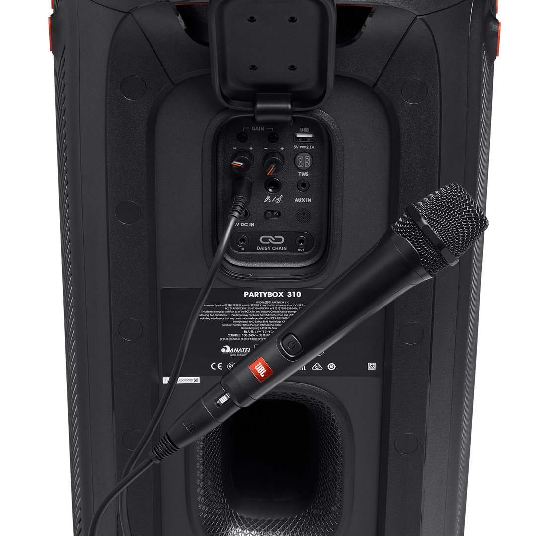 Black wired microphone plugged into the back of a speaker
