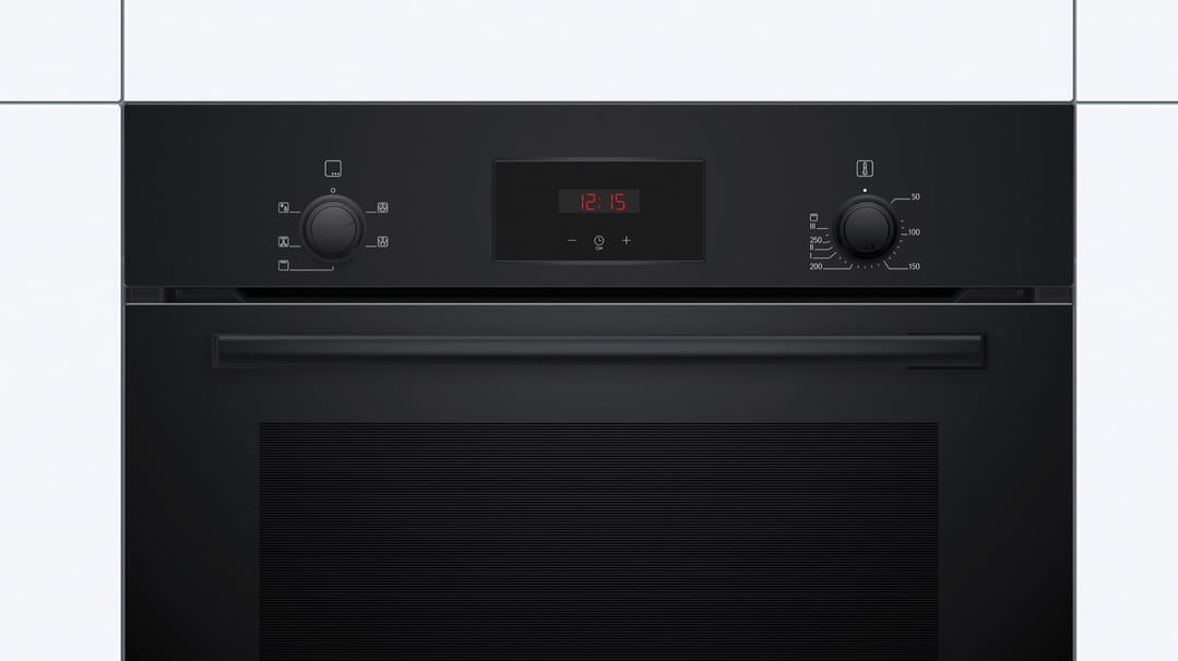 Black built-in oven with digital display and control knobs in a kitchen setting