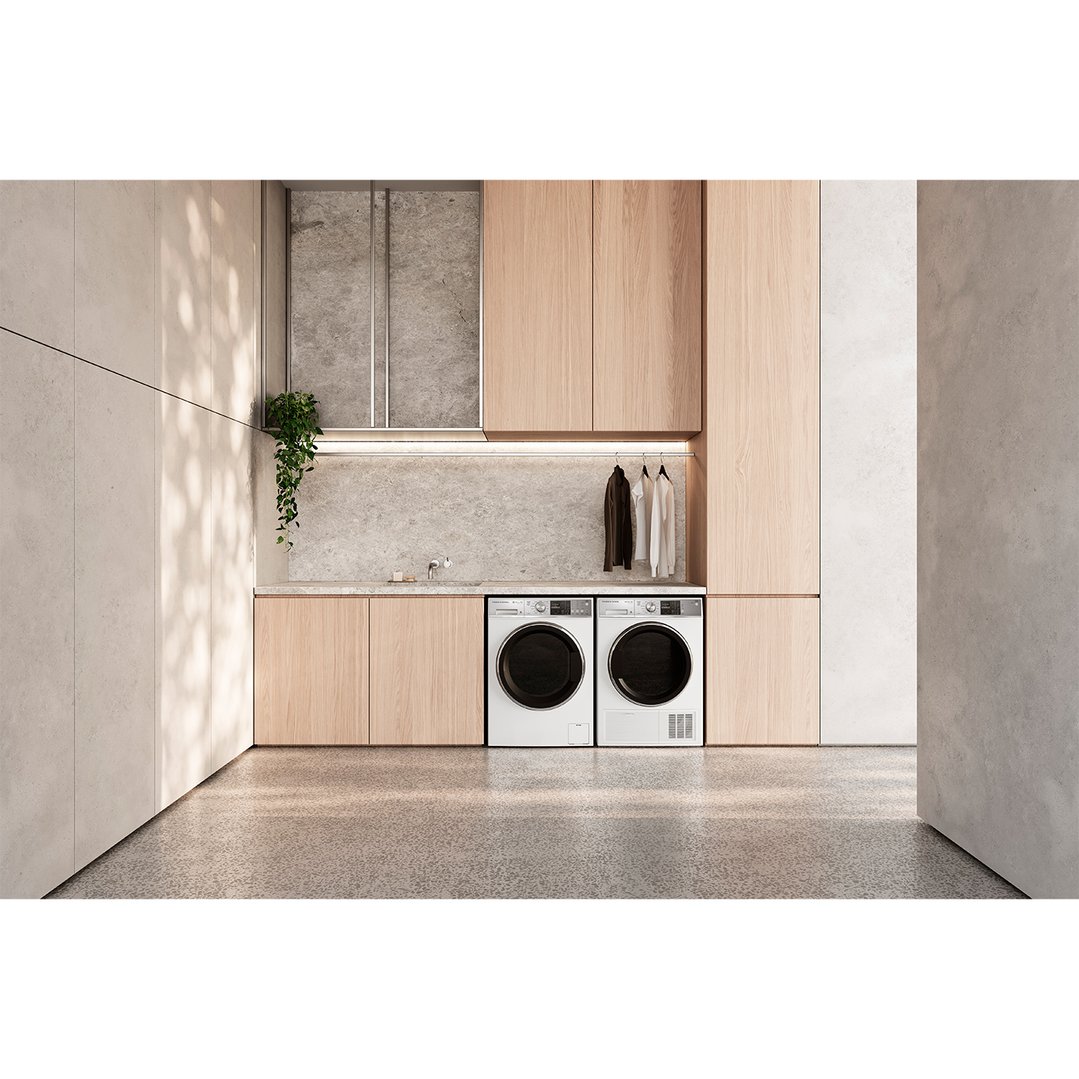 Two white dryers in a modern laundry room with wooden cabinetry